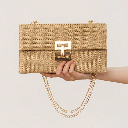 Woven handbag with chain detail held by a hand against a plain background